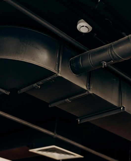 Ductos de ventilación negros bajo el techo de un edificio